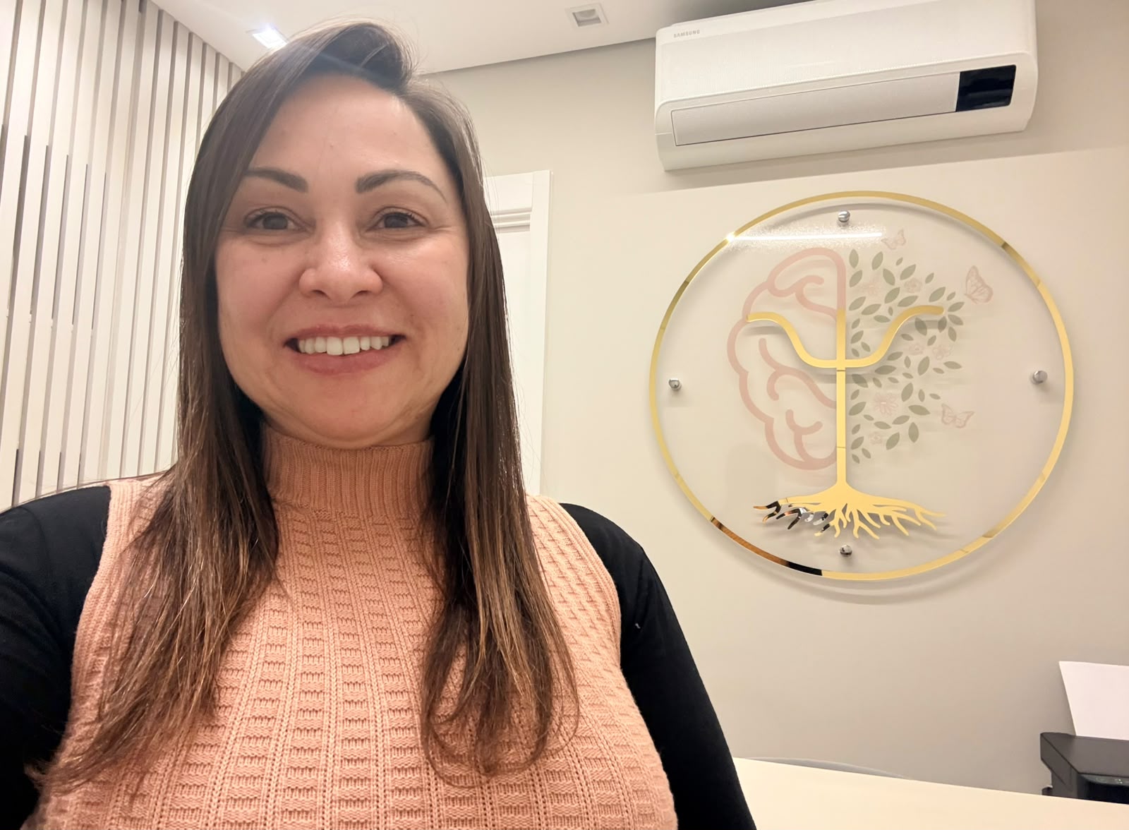 Foto da psicóloga Kátia Marquete sorrindo em seu consultório Integramente